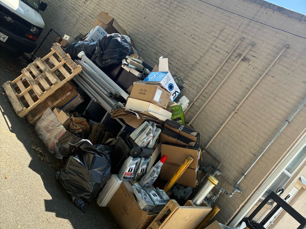Pallets, boxes, bags, and bulky junk in a Hempstead work area before removal