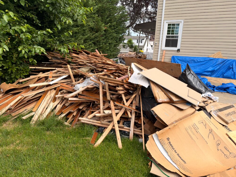 Construction debris and lumber piled in a Hicksville yard before removal